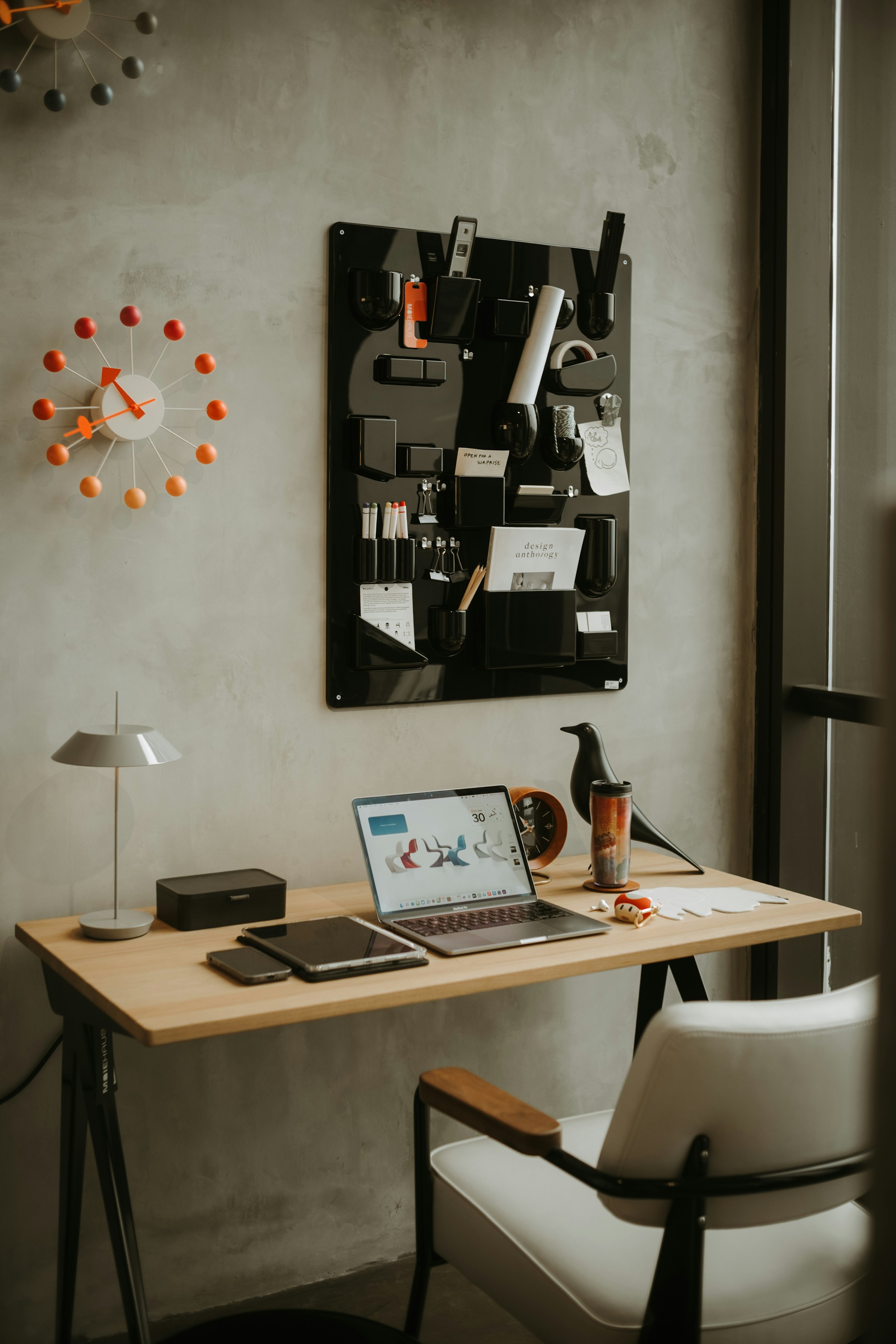 Organized modern workspace with a laptop and wall-mounted planning tools